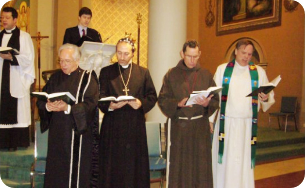 Four Clergymen of different faith traditions standing and reciting prayer together.