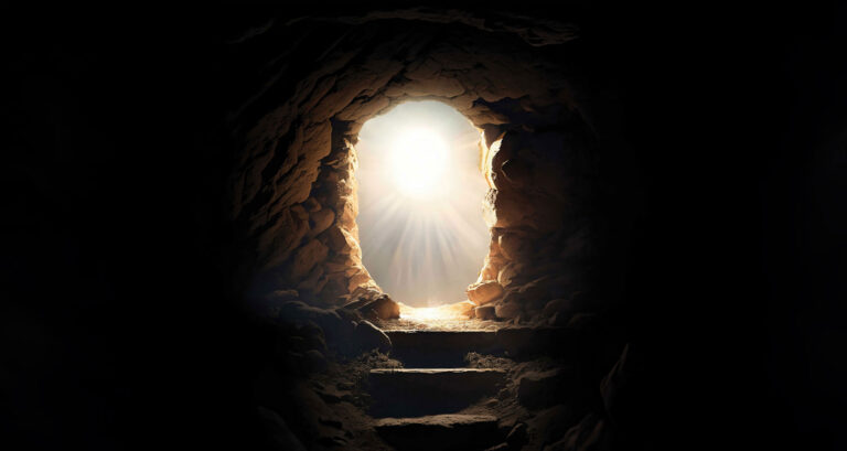 A picture from inside of a dark tomb looking looking out the entrance, bright divine light shines from the portal.